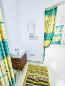 een badkamer met gordijnen, een wastafel en een tapijt bij Green Village Safari Resort in Udawalawe
