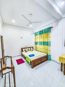 een slaapkamer met een bed en een plafondventilator bij Green Village Safari Resort in Udawalawe