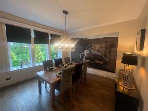 a dining room with a table and chairs and a car painting at Edwardian Manor near Glasgow City with HEATED POOL & HOT TUB in Giffnock
