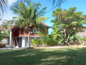 a house with palm trees in front of it at Banda Aceh Batoh Homestay - private - fits up to 8 persons in Banda Aceh