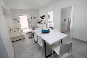 謝利比奇的住宿－Villa Plaza，白色的用餐室配有白色的桌椅