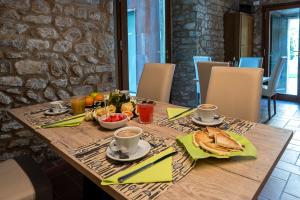 einen Holztisch mit Frühstückszutaten und Getränken darauf in der Unterkunft Borgo dei Sassi di Roccamalatina - Room and Breakfast in Rocca Malatina