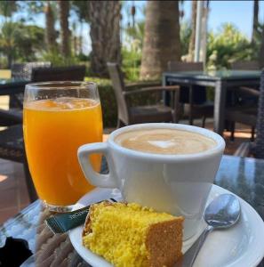 eine Tasse Kaffee und ein Stück Kuchen und ein Getränk in der Unterkunft Casa Calida in Sucina