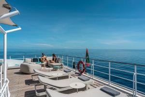 dos personas sentadas en la cubierta de un crucero en Four Seasons Explorer Palau - Cruising Resort en Koror