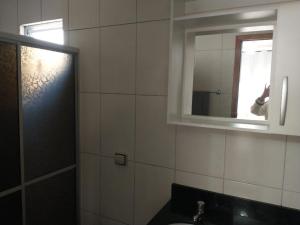 a bathroom with a mirror and a sink at Residencial Vitor Studio 5 in São José dos Pinhais