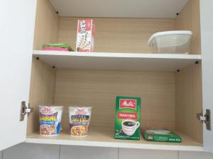 une étagère dans une armoire avec de la nourriture dans l'établissement Residencial Vitor Studio 5, à São José dos Pinhais