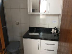 uma casa de banho com um lavatório e um WC em Residencial Vitor Studio 5 em São José dos Pinhais