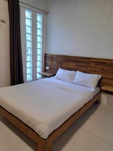 uma cama grande num quarto com uma janela em La place em Mactan