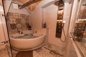 a bath tub in a bathroom with a shower at Suite Pietra Bianca - Relax & SPA in Martina Franca