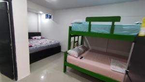 a room with two bunk beds and a small bed at La Roca Coveñas Apartamentos in Coveñas