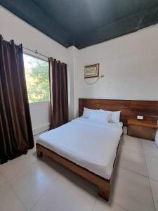 a bedroom with a large bed with a window at La place in Mactan