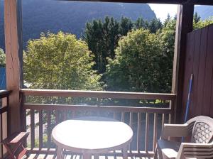 a table and chairs on a balcony with a view at Appartement entre thermes et montagne in Luchon