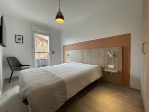 a bedroom with a large bed and a chair at Alba in Laxou