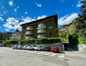 a parking lot with cars parked in front of a building at Appartamento “Del TuF” in Sondrio Centro in Sondrio