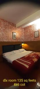 1 dormitorio con cama y pared roja en Greenview holiday inn, en Munnar