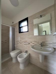 bagno con lavandino, servizi igienici e specchio di Villaggio Almar a Vieste