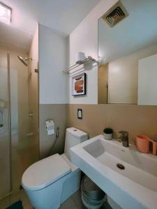 a bathroom with a white toilet and a sink at Calyx Residences by Hooga Home 3minutes walk to Ayala Center Cebu in Cebu City