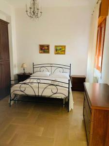 ein Schlafzimmer mit einem Bett, einer Kommode und einem Kronleuchter in der Unterkunft Curtatone 170 in Vittoria
