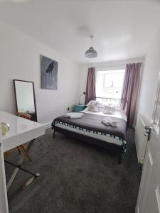 um quarto com uma cama, uma mesa e um espelho em bEaUtiFUL and Bright !! Town/Harbour apartment #2 em Penzance
