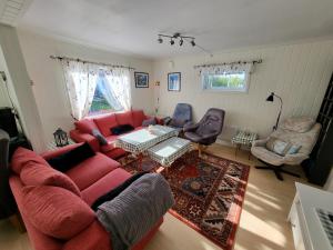 sala de estar con sofá rojo y sillas en Paul's House, en Saltstraumen