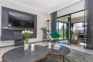 a living room with a table and a tv at Urban Oasis - 3 Bedroom Home in Sandton