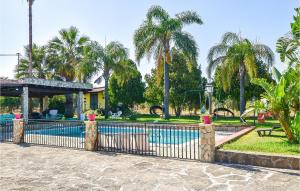 een hek voor een zwembad met palmbomen bij Lovely Home In Melilli With Kitchenette in Melilli