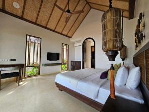 Schlafzimmer mit einem Bett, einem Schreibtisch und einem TV in der Unterkunft Samed Tamarind Beach Resort in Ko Samed