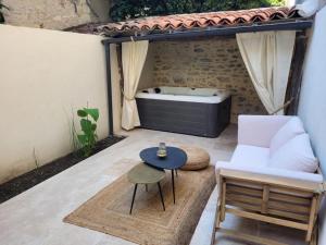 een patio met een hot tub, een stoel en een tafel bij Lieu unique cœur de ville avec terrasse et jacuzzi in Cahors