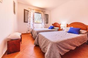 a bedroom with two beds with blue pillows at Rosa de los james in Cardón