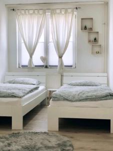 2 camas en un dormitorio con 2 ventanas en Holiday Home Cologne with Balkon - near Cologne Fair - temporary living-, en Colonia