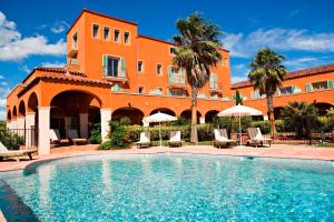 ein Hotel mit einem Pool vor einem Gebäude in der Unterkunft Palmyra Golf Hotel & Spa in Cap d'Agde