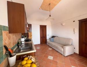 een keuken met een wastafel en een bank in een kamer bij Casa Armeno a Ravello in Ravello