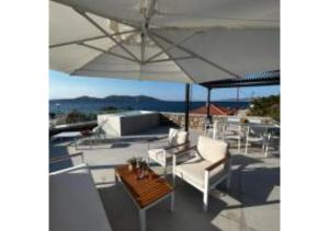 une terrasse avec des chaises, un parasol et une table dans l'établissement On The Sea Suite&Spa, à Methana