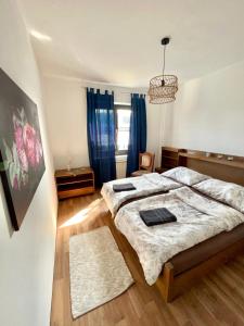 una camera con due letti e un lampadario a braccio di Mediterrane Ferien Villa am Neusiedler See a Gols