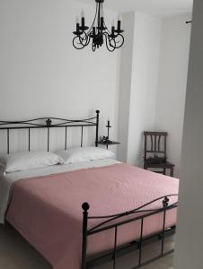 a bedroom with a bed with a pink blanket and a chandelier at AGRITURISMO TERRAPIA in Moscufo