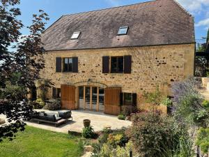 an external view of a stone house with a patio at Le Clos Saint James 5 étoiles in Domme