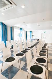 a row of white chairs in a room with blue curtains at Hotel Londres Estoril / Cascais in Estoril +37 photos