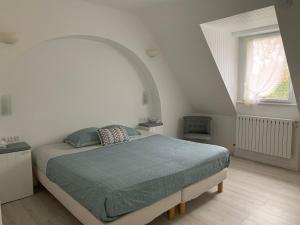 1 dormitorio con 1 cama en una habitación blanca en La Gentilhommière, en Tréffiagat