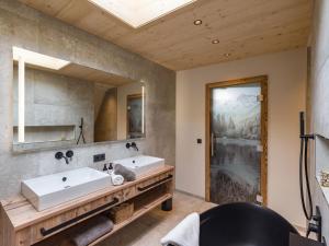 a bathroom with two sinks and a mirror at Villa Himmlgassl Private Spa in Zellbergeben