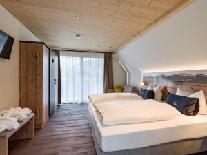 a bedroom with two beds and a large window at Villa Himmlgassl Private Spa in Zellbergeben