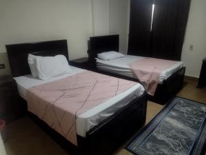duas camas num quarto com lençóis cor-de-rosa em القاهره no Cairo
