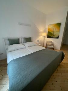 a bedroom with a large bed and a painting on the wall at Apartment Zum Dom in Graz