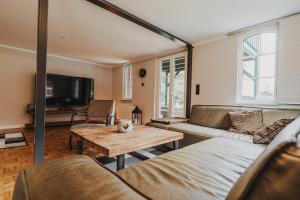 ein Wohnzimmer mit einem Sofa und einem Tisch in der Unterkunft Ferienhaus Saustall - Deichhof Dangast in Dangast
