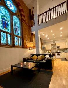 a living room with a couch and a table at Magical Church Conversion in Watford in Watford