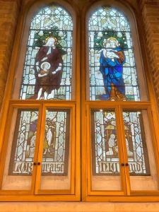 three stained glass windows in a building at Magical Church Conversion in Watford in Watford