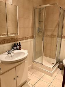 a bathroom with a sink and a shower at Magical Church Conversion in Watford in Watford