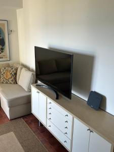 a living room with a flat screen tv on a cabinet at Mati Seaside Studio in Mati