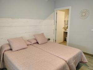 a bedroom with a bed with two pink pillows at Posada de la plata in Valdesalor