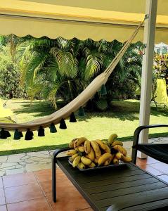 a tray of bananas on a table with a hammock at Villa Mambo in Sainte-Anne