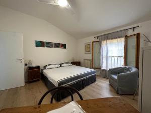 ein Schlafzimmer mit einem Bett, einem Stuhl und einem Tisch in der Unterkunft Casa Zaira in Bazzano Bologna